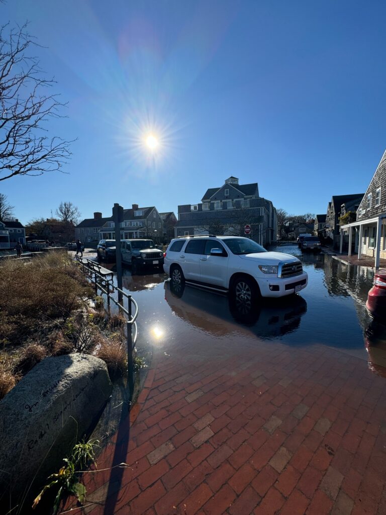 a white car parked on a brick road with a building in the background (MyCoast AI)