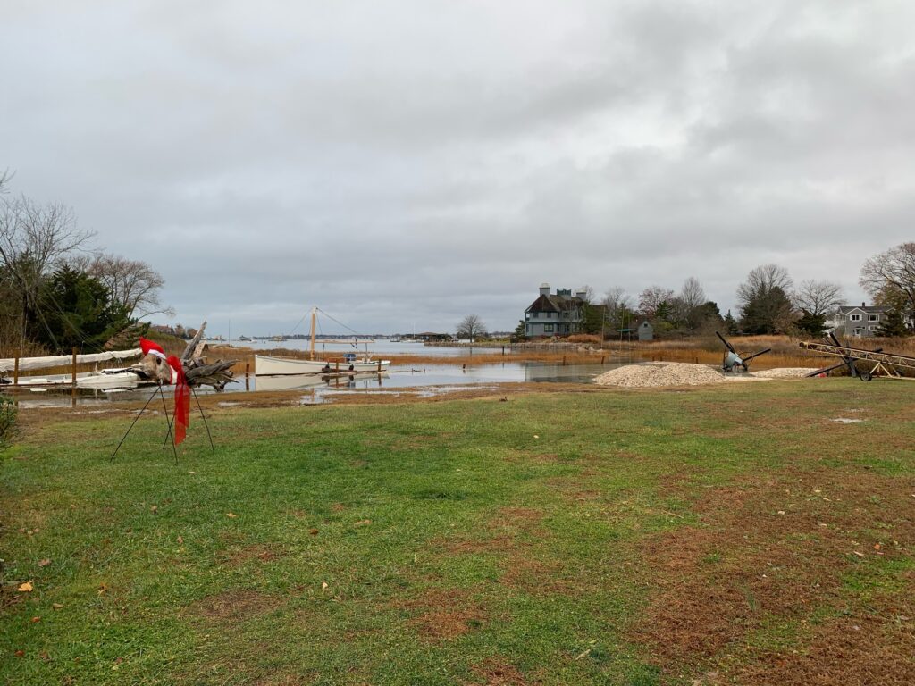 a field with a fence and a body of water in the background (MyCoast AI)