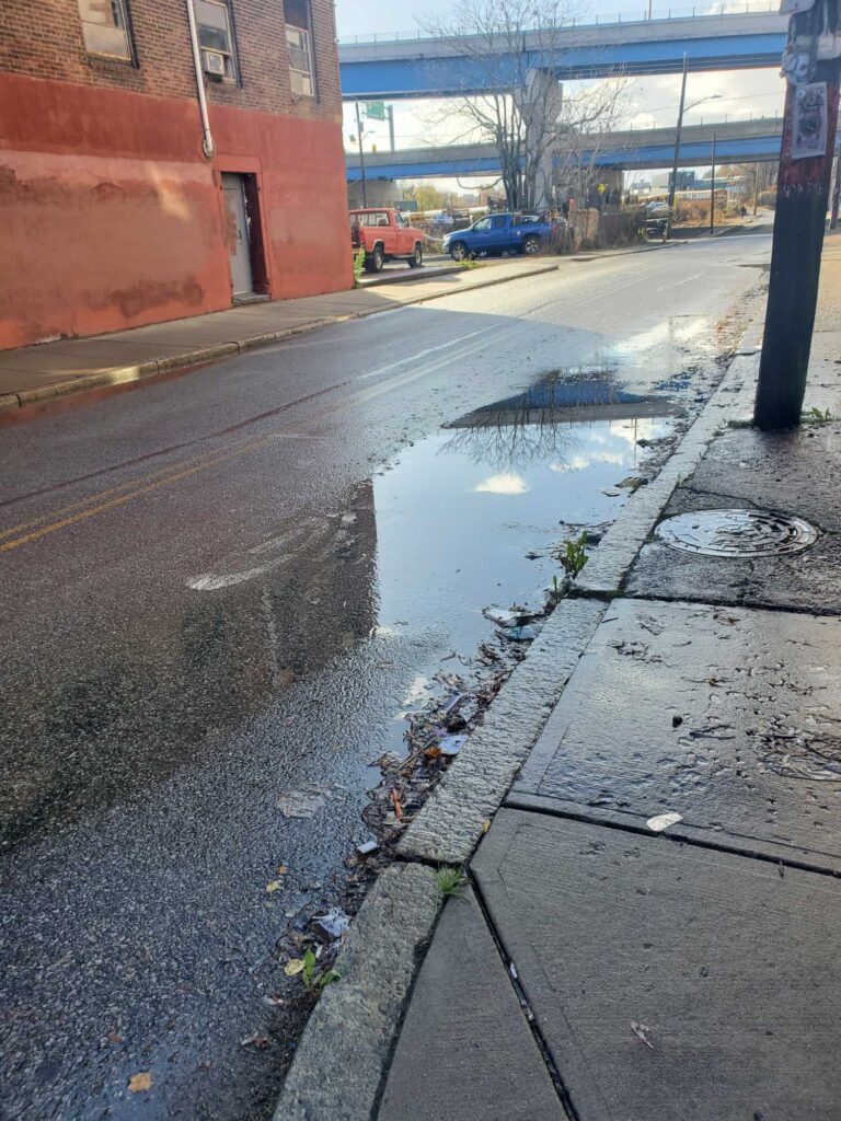 a wet street with a puddle (MyCoast AI)