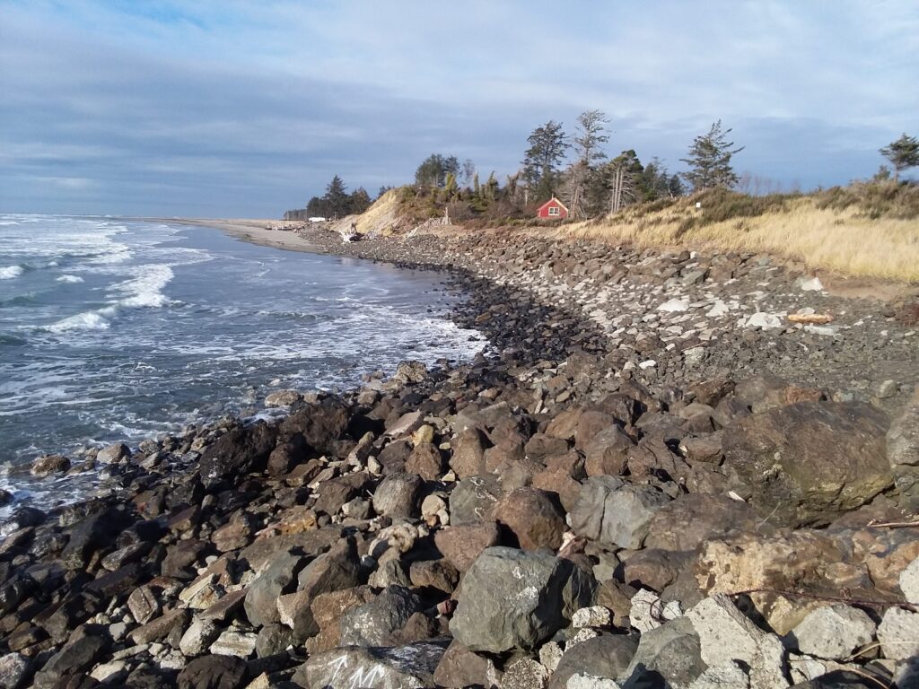 a rocky beach with a red house (MyCoast AI)