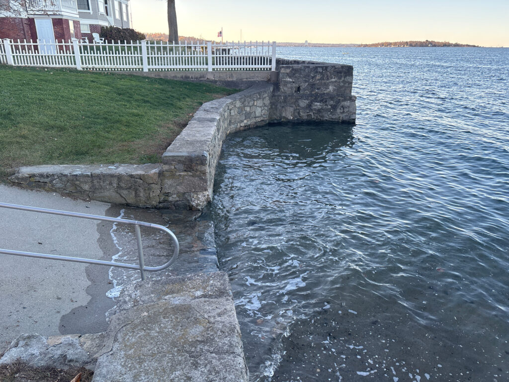 a body of water with a stone wall and a fence around it (MyCoast AI)