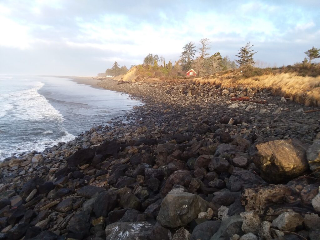a rocky beach with a house in the distance (MyCoast AI)
