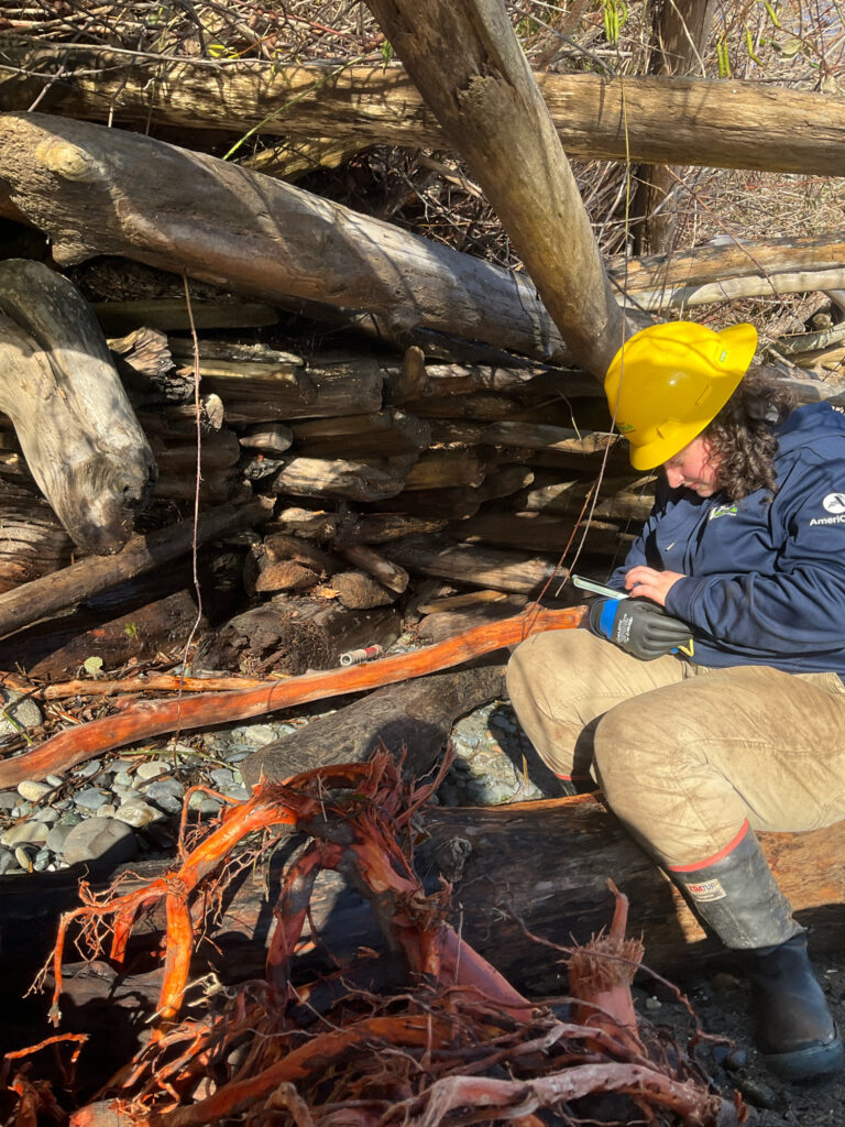 a man in a yellow hat sitting next to a fire (MyCoast AI)