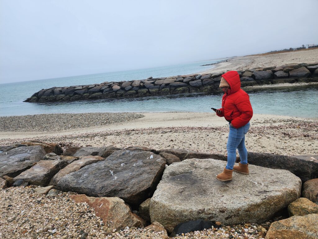 a child standing on a rock by the water (MyCoast AI)