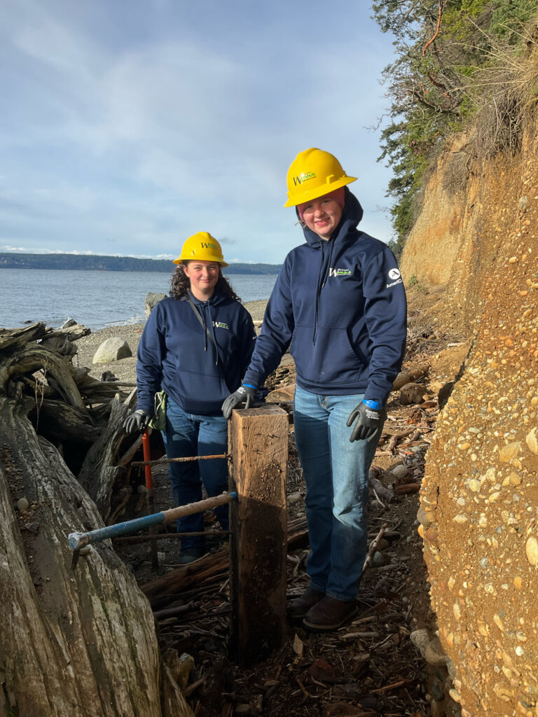 a couple of people wearing hard hats and standing on a wooden bridge (MyCoast AI)