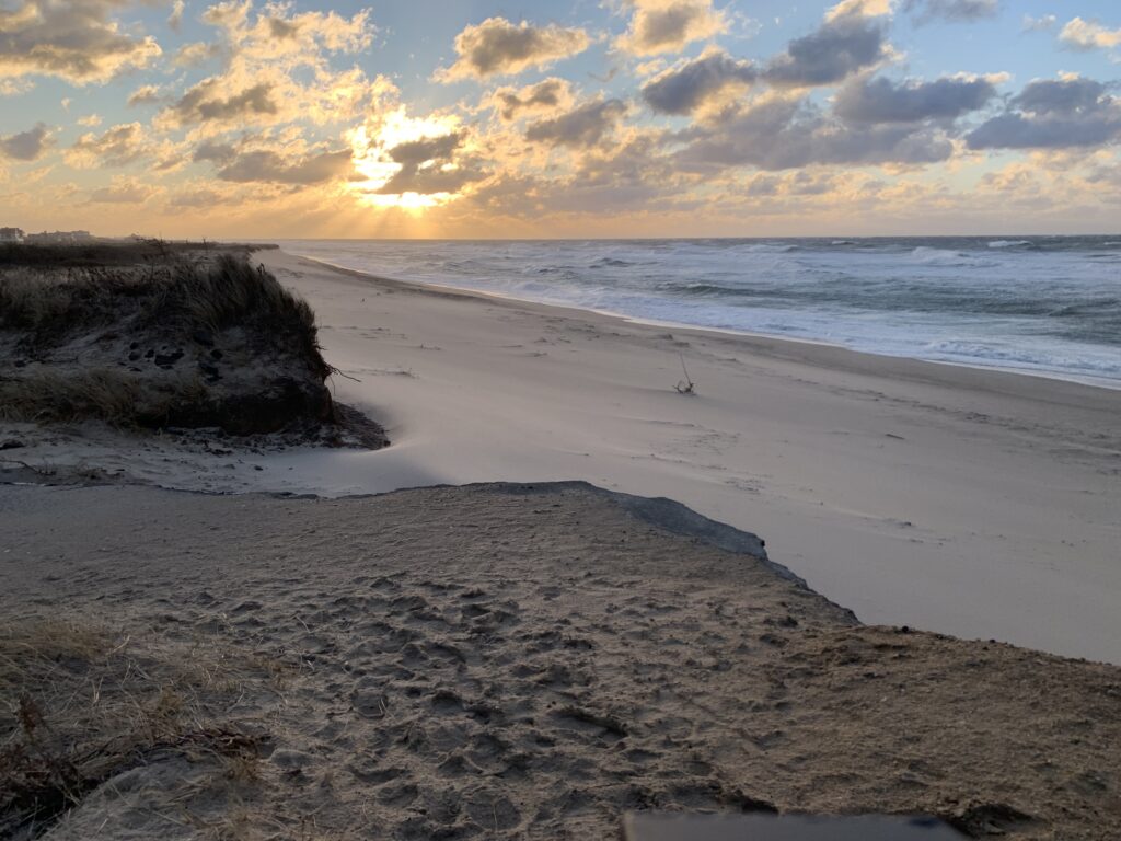 a sandy beach with a body of water and a sunset (MyCoast AI)