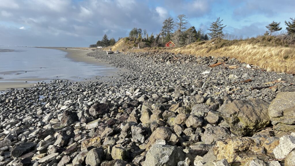 a rocky beach with a house in the distance (MyCoast AI)