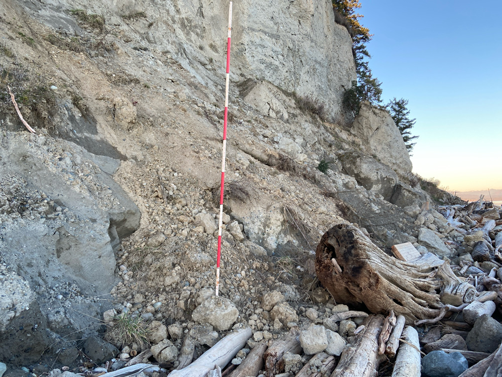 a rocky cliff side with a red rope and a red pole (MyCoast AI)