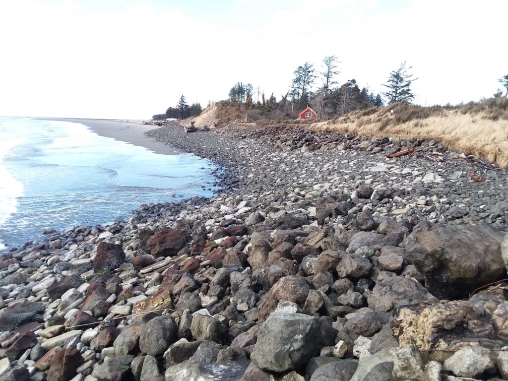 a rocky beach with a red house (MyCoast AI)