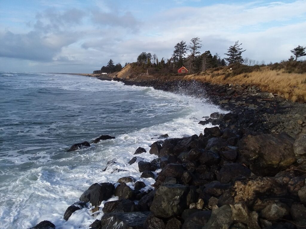 a rocky beach with a house in the distance (MyCoast AI)