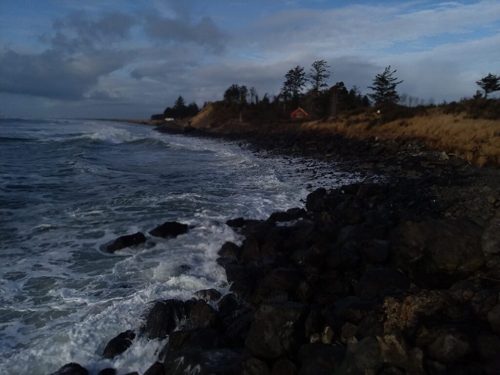 a rocky beach with a house in the distance (MyCoast AI)