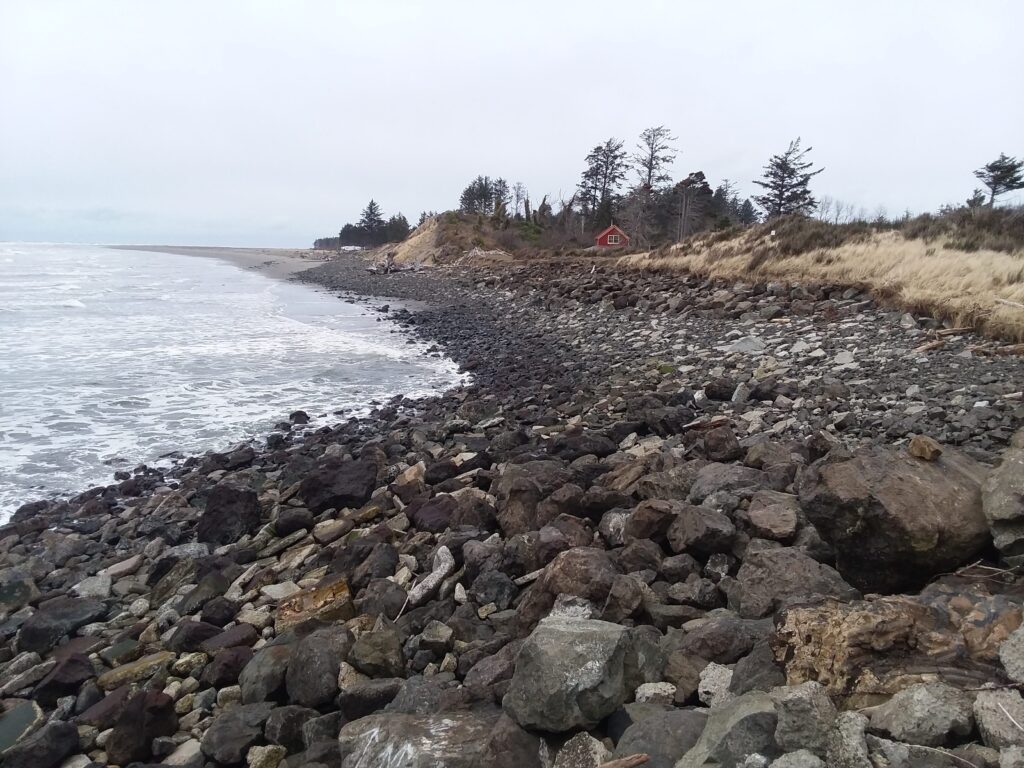 a rocky beach with a red house (MyCoast AI)