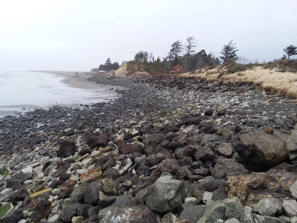 a rocky beach with a house in the distance (MyCoast AI)