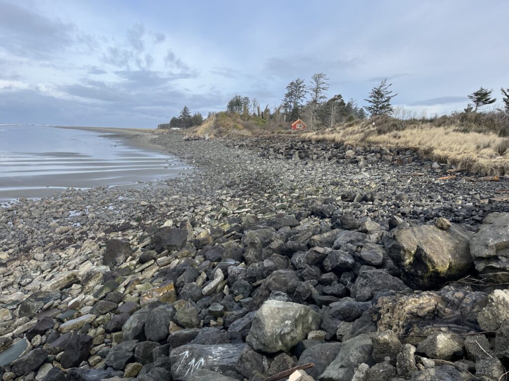 a rocky beach with a small house (MyCoast AI)