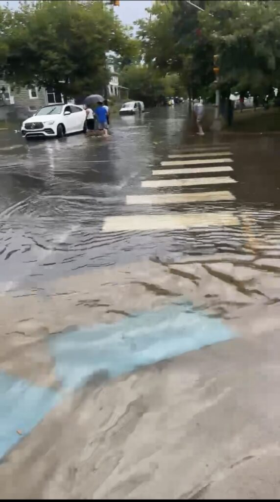 a person holding an umbrella in a flooded street (MyCoast AI)