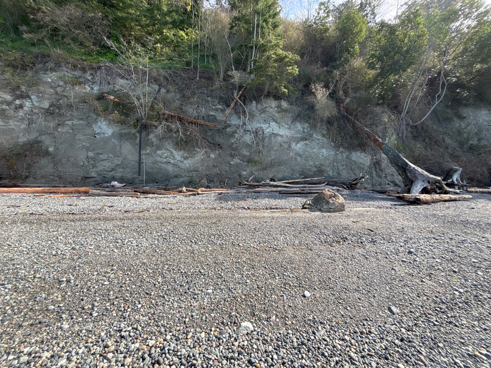 a large pile of debris on the ground next to a rocky hill (MyCoast AI)