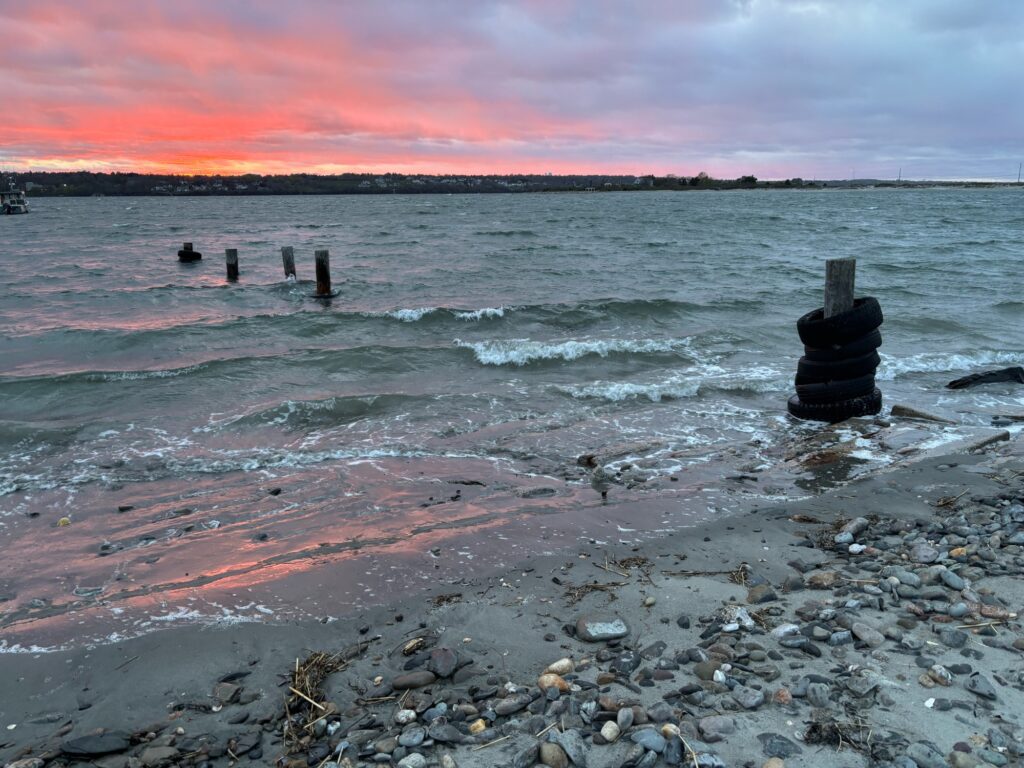 a rocky beach with a body of water and a sunset (MyCoast AI)