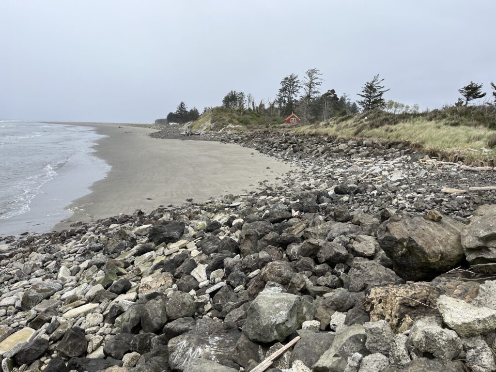a rocky beach with a house in the distance (MyCoast AI)