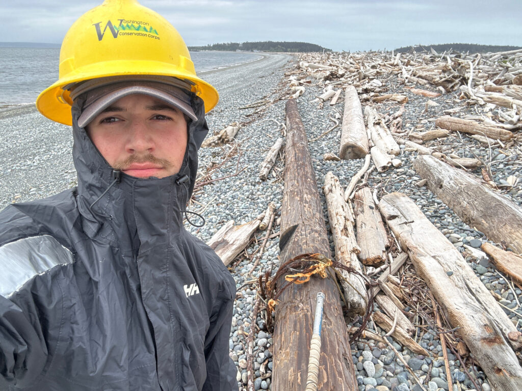 a person standing next to a pile of fish on a beach (MyCoast AI)