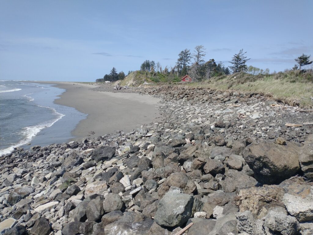a rocky beach with a red house (MyCoast AI)