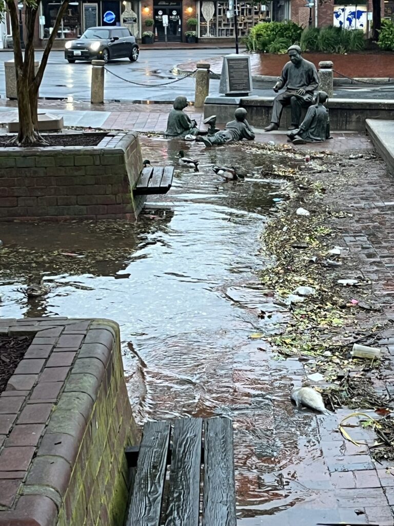 a group of people sitting on a bench in a flooded area (MyCoast AI)