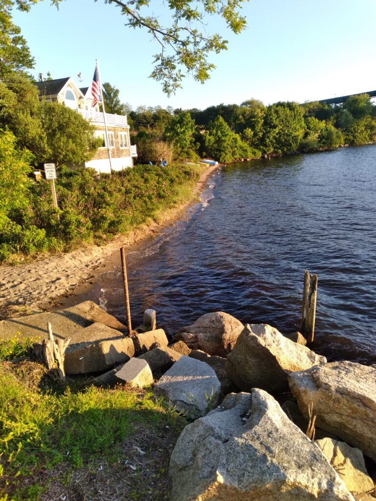 a body of water with rocks and a building in the background (MyCoast AI)