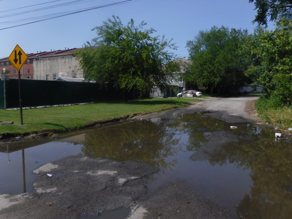 a flooded street with a yellow sign (MyCoast AI)