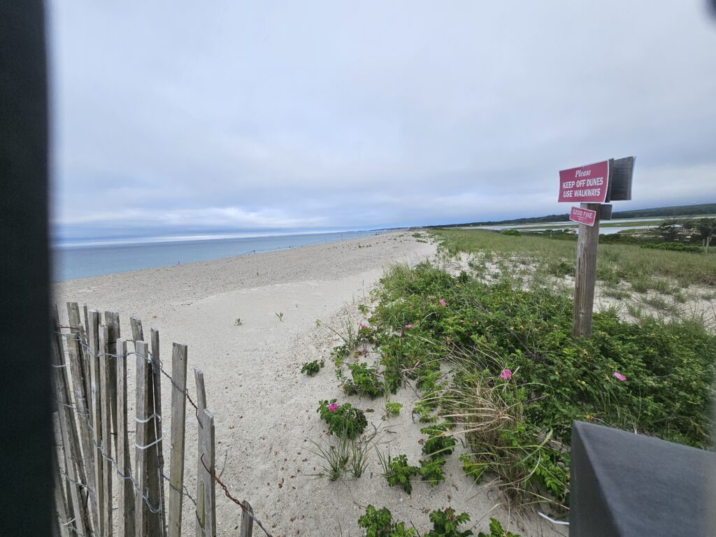 a beach with a fence and a sign (MyCoast AI)