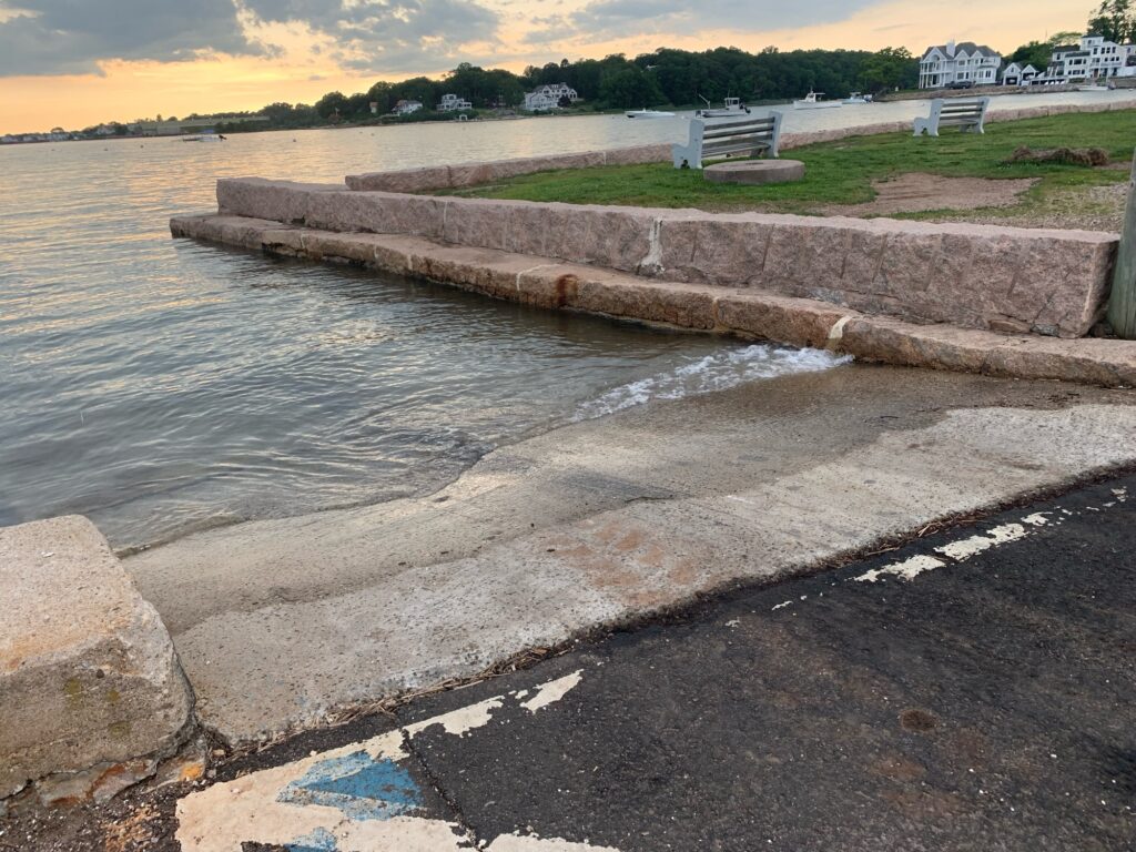 a body of water with a concrete wall and a bench (MyCoast AI)