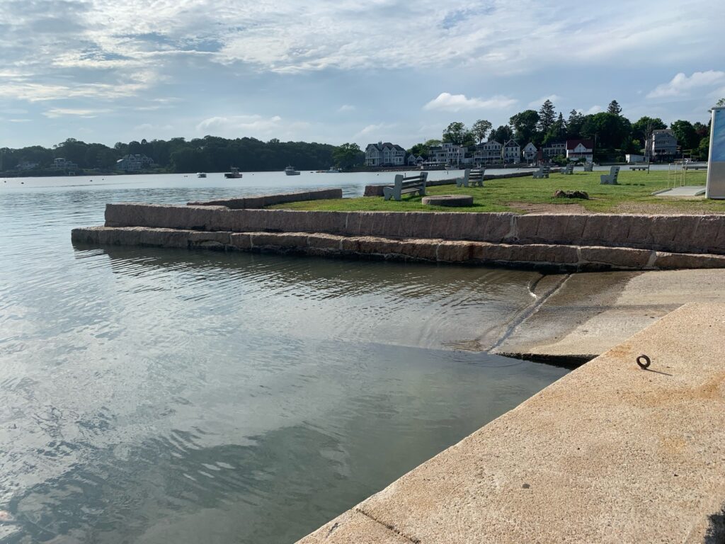 a body of water with a concrete wall and grass and trees in the background (MyCoast AI)