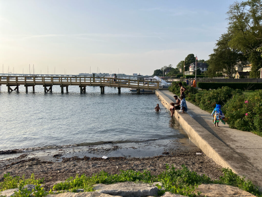 a group of people sitting on a bench by a body of water (MyCoast AI)