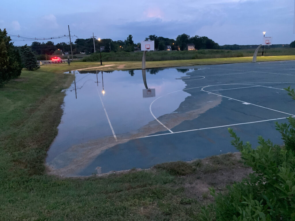 a flooded road with a car driving by (MyCoast AI)