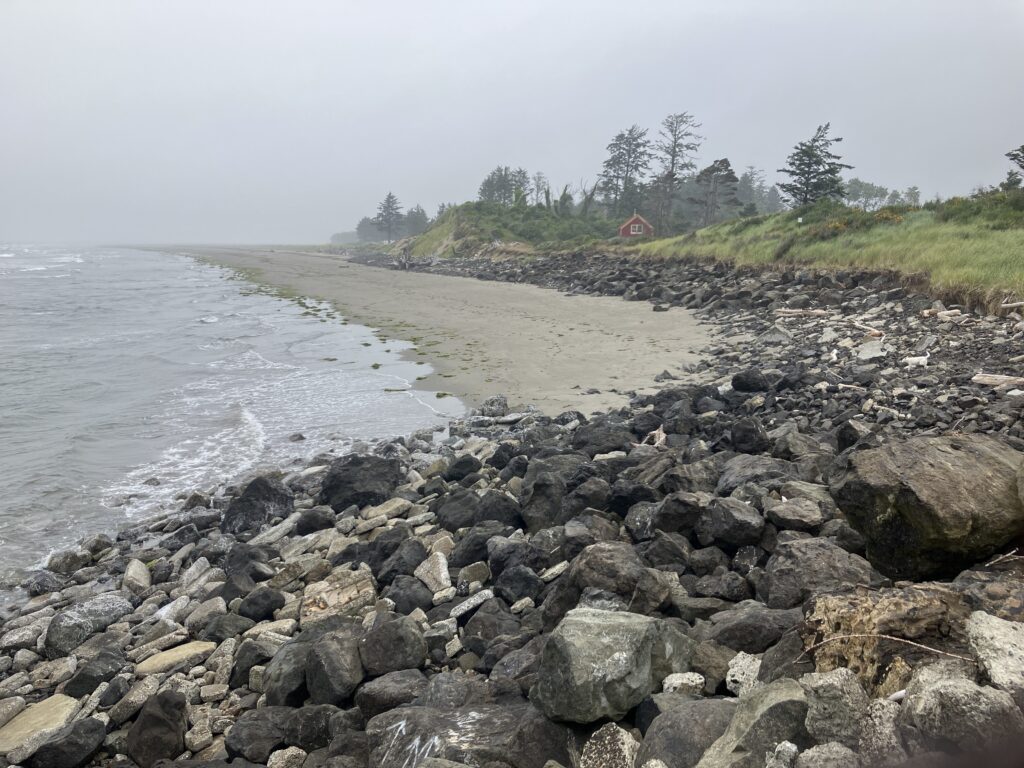 a rocky beach with a house in the distance (MyCoast AI)