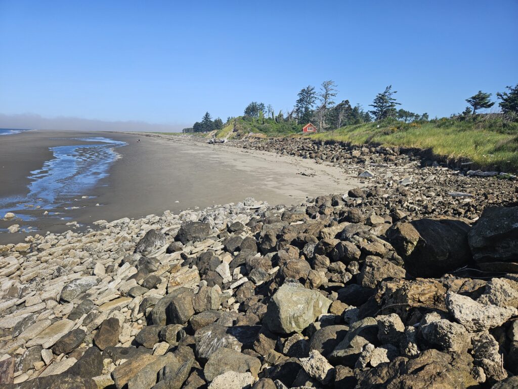 a rocky beach with a small house (MyCoast AI)