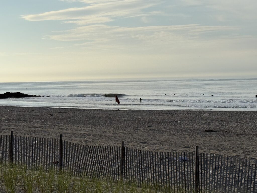 a person holds a surfboard on a beach (MyCoast AI)