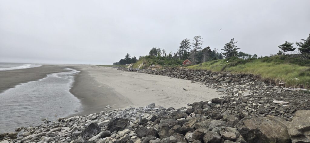 a rocky beach with a house in the distance (MyCoast AI)