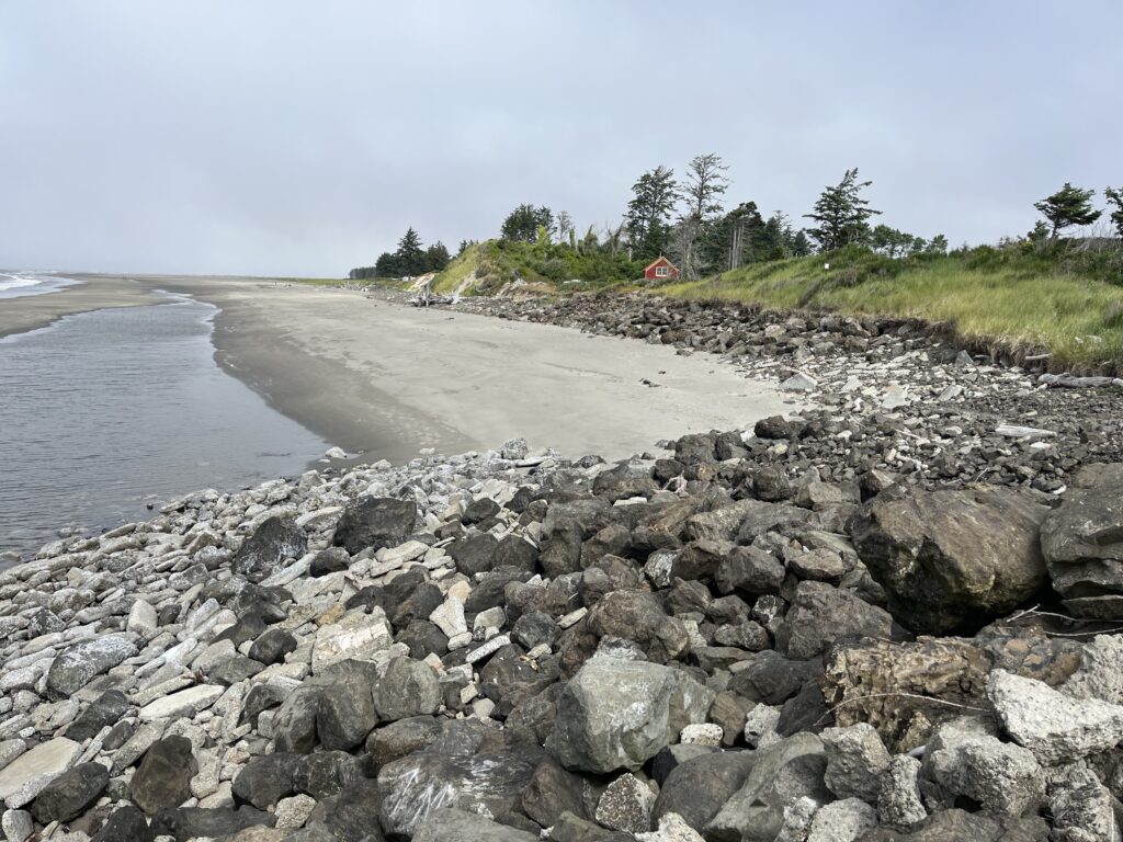 a rocky beach with a house in the distance (MyCoast AI)