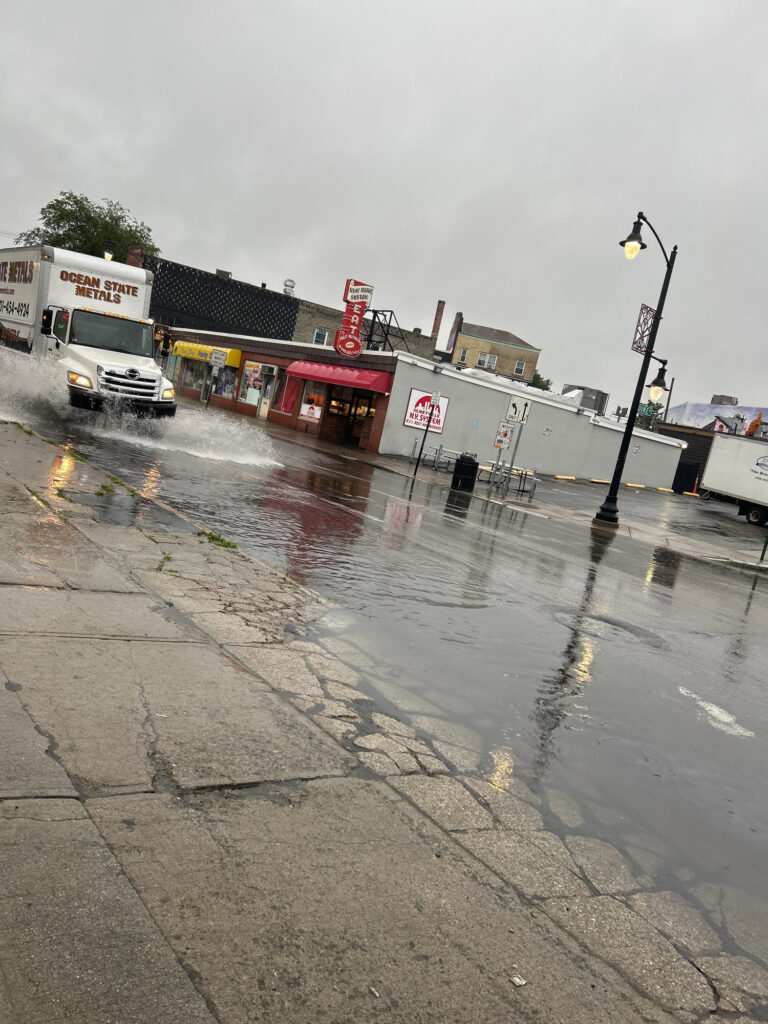 a wet street with a few trucks (MyCoast AI)