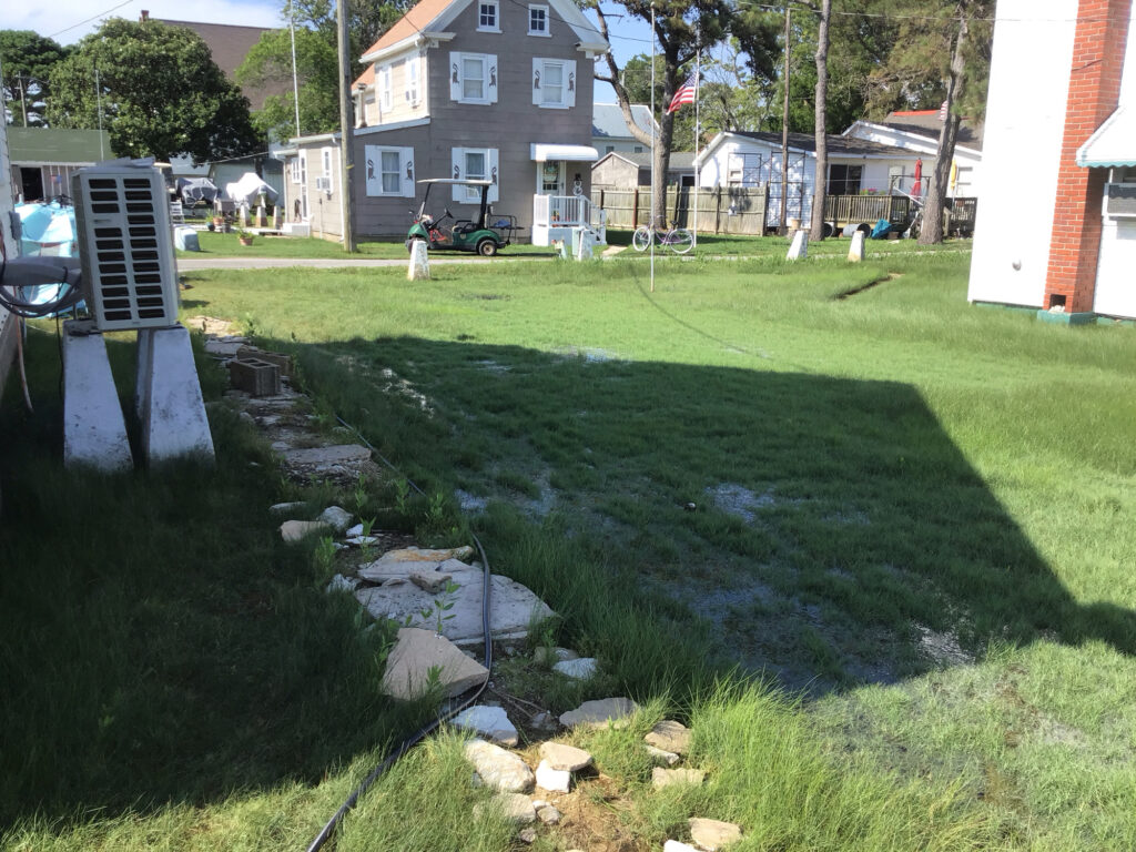 a yard with a pond and a person standing in it (MyCoast AI)