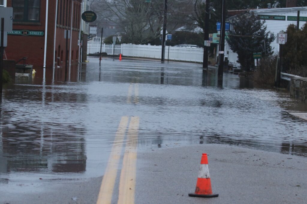 a road with a traffic cone on it and a puddle of water on the side (MyCoast AI)