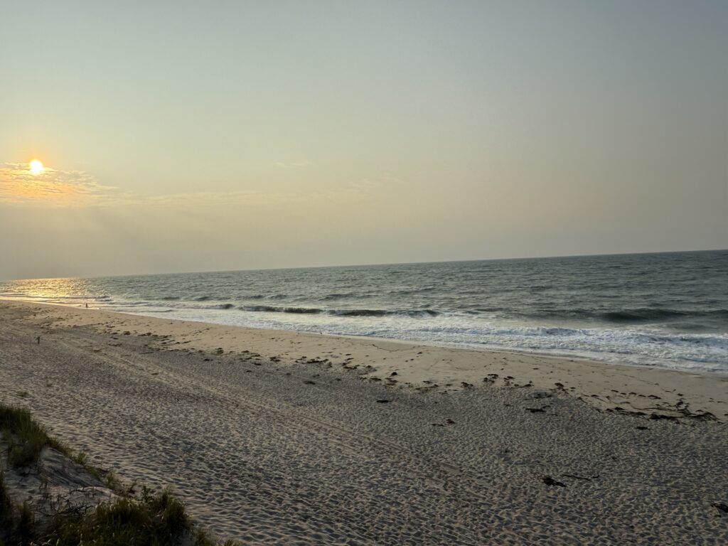 a beach with waves and the sun setting (MyCoast AI)