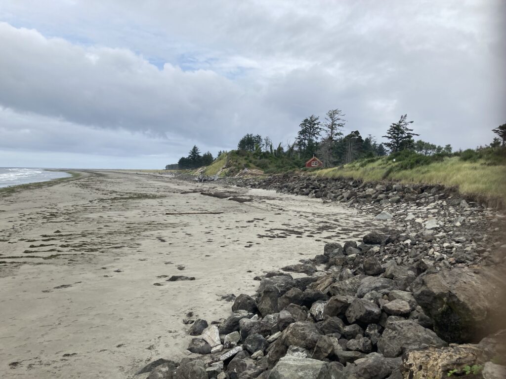 a rocky beach with a house in the distance (MyCoast AI)