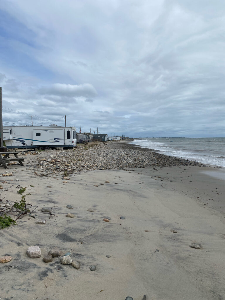 a beach with a boat and a building in the background (MyCoast AI)