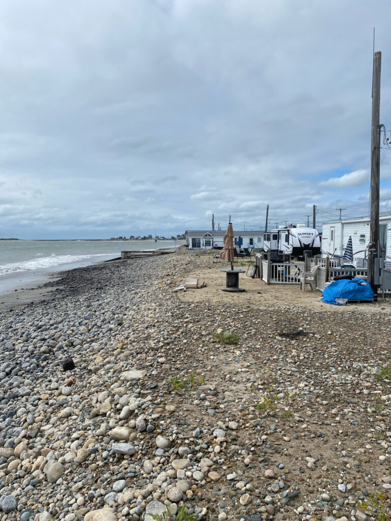 a rocky beach with a building in the background (MyCoast AI)