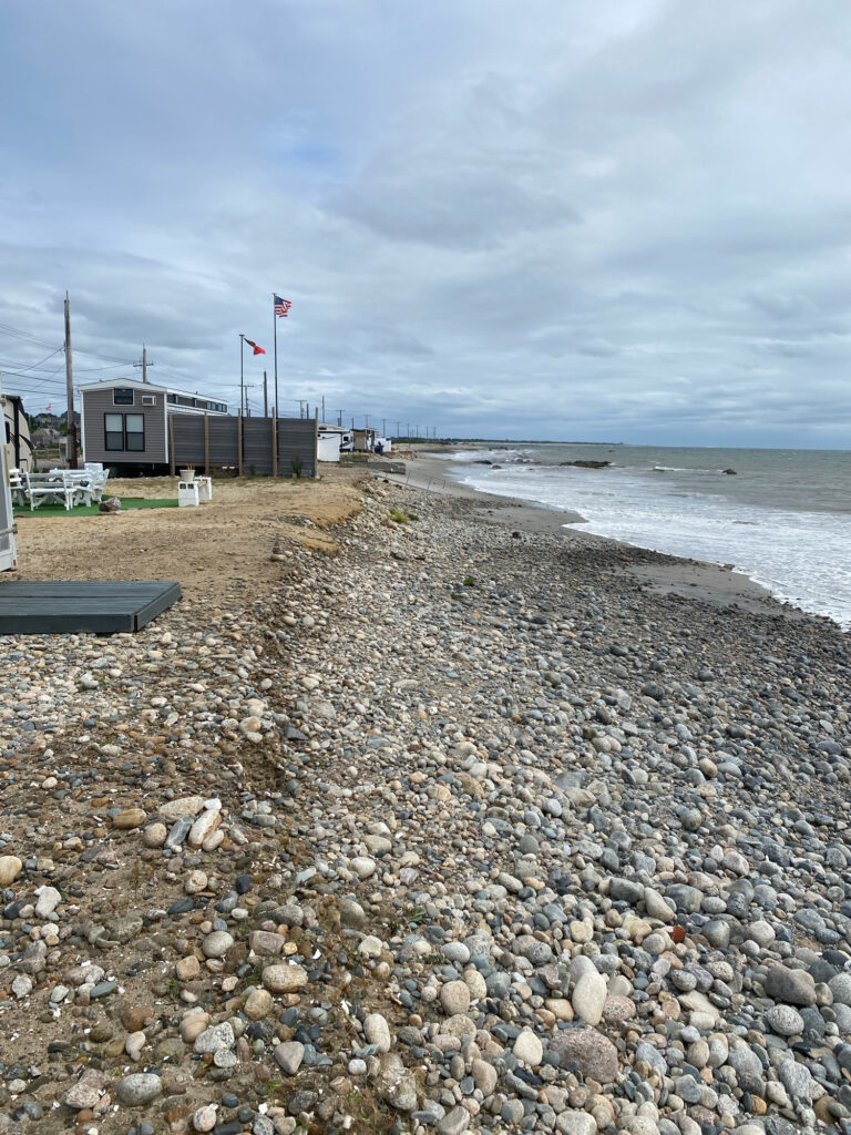 a rocky beach with a building and flags (MyCoast AI)