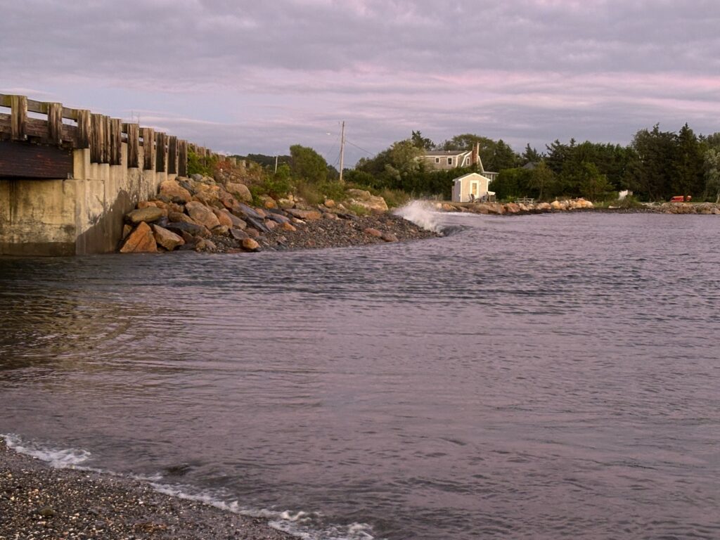 a body of water with rocks and a building in the background (MyCoast AI)