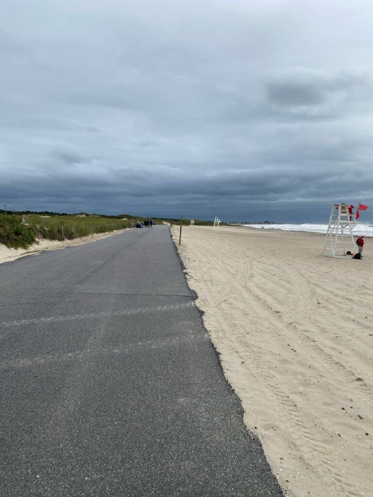 a road with a ladder on the side and a body of water in the background (MyCoast AI)