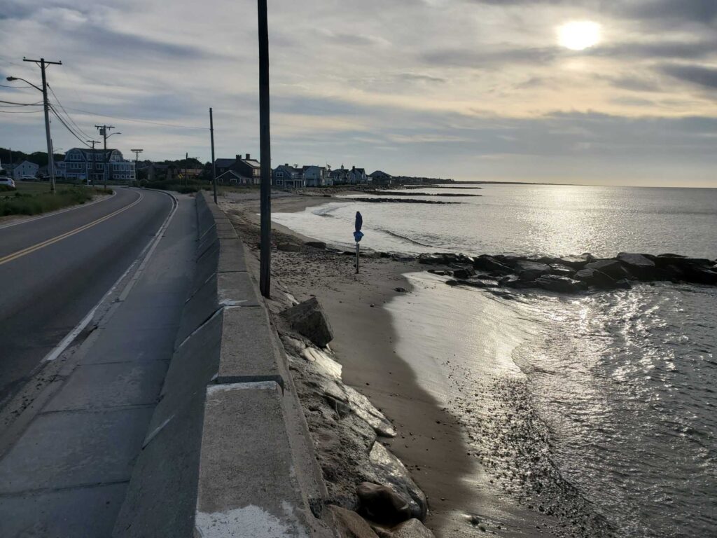 a person standing on a road next to a body of water (MyCoast AI)