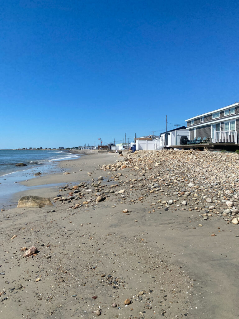 a rocky beach with buildings and water (MyCoast AI)