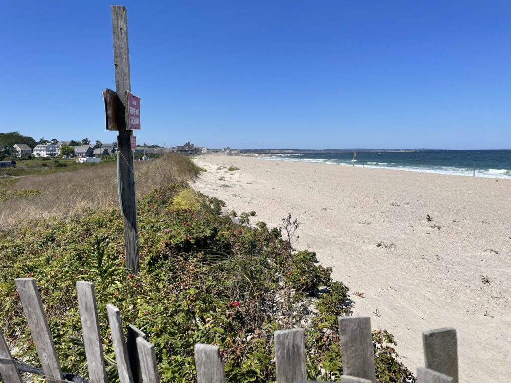 a beach with a fence and a sign (MyCoast AI)